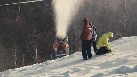 Man stands on the background of working snow cannons. Amazing view. Winter sport 스톡 동영상 97797756