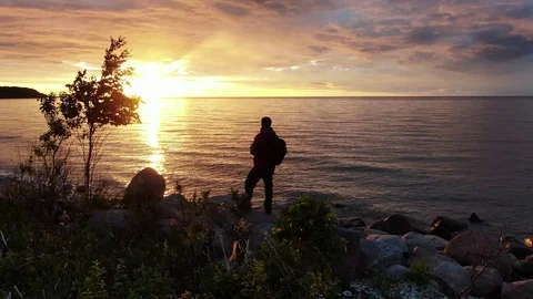 Man stands in the backlight by the sea Stock Footage 115237849