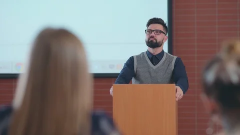 Man stands behind the pulpit and explains material to students. Stock Footage 88805367