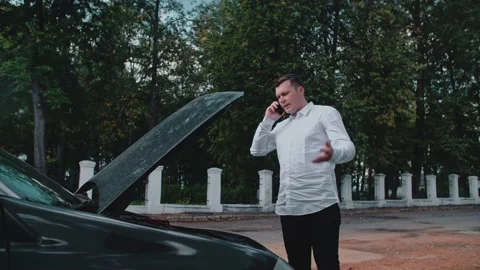 A man stands by the car talking to the foreman on the phone and talks Stock Footage 150122092