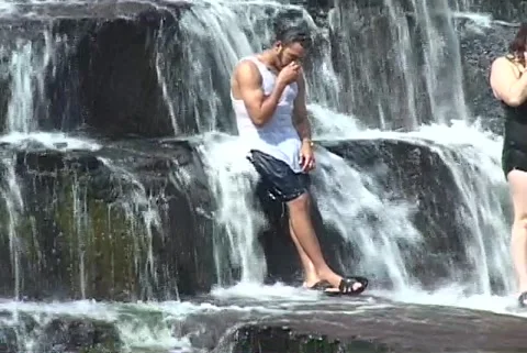 Man stands in cascading waterfall Video stock 192544021