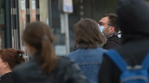 Man stands in crowd of people. Human in protective mask. Coronavirus. Covid-19. Stock Footage 129789130