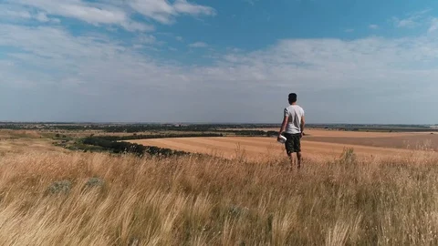 A man stands on the edge of a cliff and looks into the distance Stock Footage 112992387