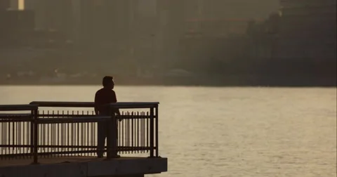 Man stands on end of pier as NYC Waterway boat passes by in slow motion Stock Footage 67276643