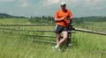 Man stands in a field and makes photos on his smartphone HD Footage