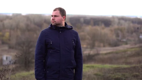 A man stands in a field and talking on the phone. Stock Footage 127443887