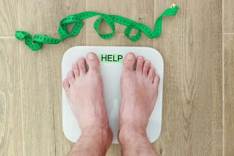 A man stands on a floor scale on the floor top view. overweight Stock-Fotos
