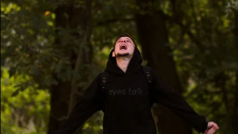 A man stands in the forest, yelling angrily Stock Footage 287619677