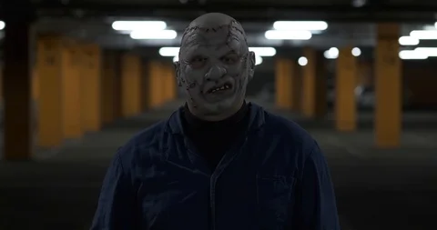 Man stands in front of camera, raises his hand, shows victory sign, scary look Stock Footage 118875095