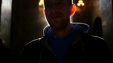 A man stands in front of the light from the window, with lens effects. HD Stock Footage 78931041