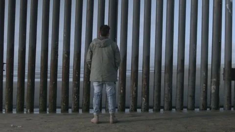 Man Stands In Front Of Mexico Border Wall Stock Footage 100567967