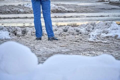 A man stands in front of the road during slush Stock Photos