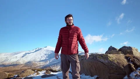 The man stands in front of the snowy mountain Stock Footage 145303155