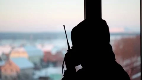 Man stands in front of the window speaks briefly into the walkie-talkie Stock Footage 146775766