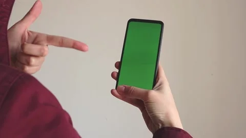 The man stands with his back turned and holds a phone with a green screen. Stock Footage 153858161