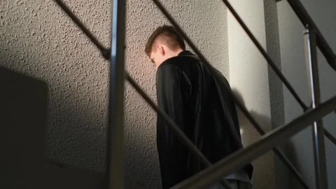A man stands with his head to the wall on the landing of a house Stock Footage 277165176