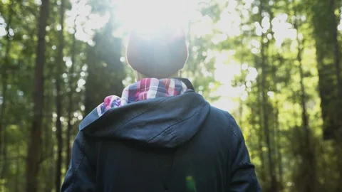 Man stands looking into forest jungle then walks in Stock Footage 102807601