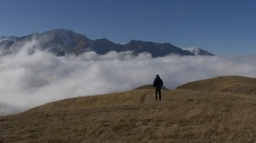 Man stands on a mountain above the clouds Video stock 85597973