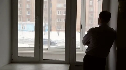 A man stands near window Stock Footage 72691934