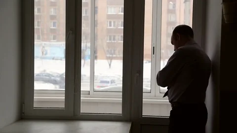 A man stands near window Stock Footage 72692040