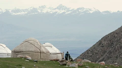 A man stands outside his yurt in the Mountains of Kyrgyzstan. Stock Footage 197899509