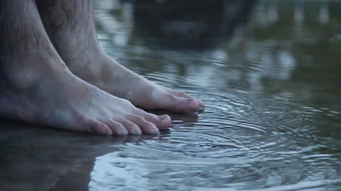 Man stands in a puddle after the rain with bare feet Stock Footage 107991271