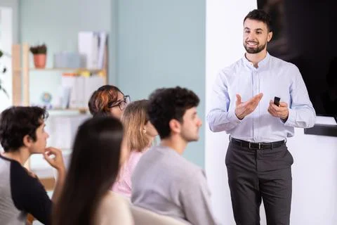 Man stands with a remote control in front of students Stock Photos