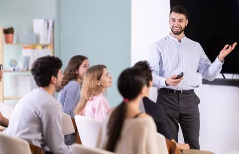 Man stands with a remote control in front of students Stock Photos