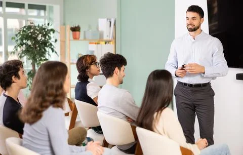 Man stands with a remote control in front of students Stockfoto's