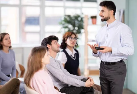 Man stands with a remote control in front of students Stockfoto's