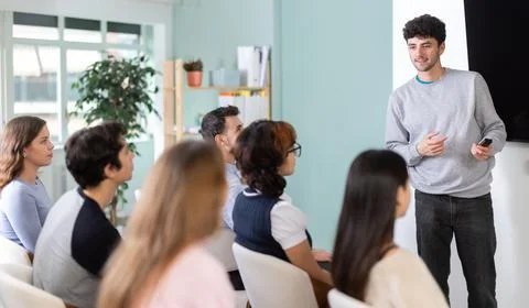 Man stands with a remote control in front of students Stockfoto's