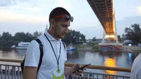 Man stands by the river and uses a mobile phone 스톡 동영상 103946293