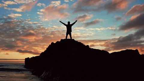 Man stands on a rock  is looking distance during beautiful summer sunset. H.. Stock Footage 262436622