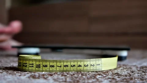 A man stands on a scale to measure weight Stock Footage 202645293