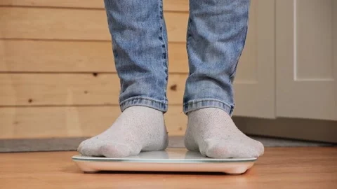 Man stands on the scales. The guy is weighing himself. Floor scales for health Stock Footage 239448367