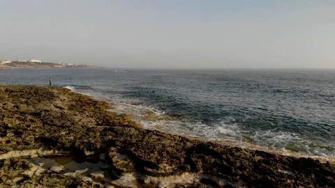 A man stands on the seashore.  Beach and sea. 4K Stock Footage 104656038
