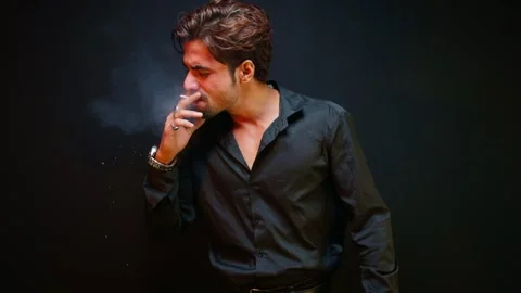 Man stands smoking looking perplexed and unsure Stock Footage 298244102