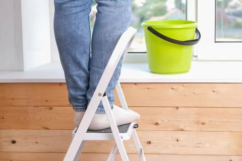 A man stands on a stepladder and washes window from above. Feet on the stairs Stock Photos