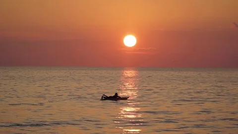 A man stands on a surfboard on a sunset background Video stock 119855667