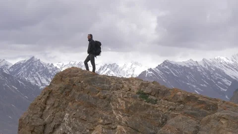 Man stands on top of a mountain background of Himalayas snowy peaks Stock Footage 141793982