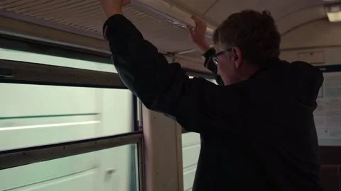 Man stands train window and looks out window in passing trains. slow motion. Stock Footage 234186330