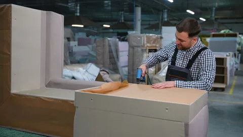 Man Stapling Upholstery Fabric on Sofa Base Video stock 305612087