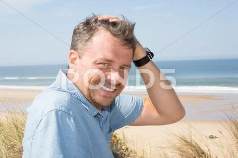 Man staring at the camera wearing a shirt on ocean Stock Photos