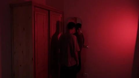 Man staring at his reflection before lowering his head and resting against the Stock Footage 347301354