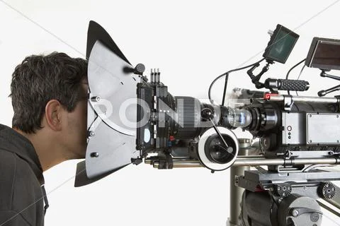 A man staring into the lens side of a film camera Stock Photos