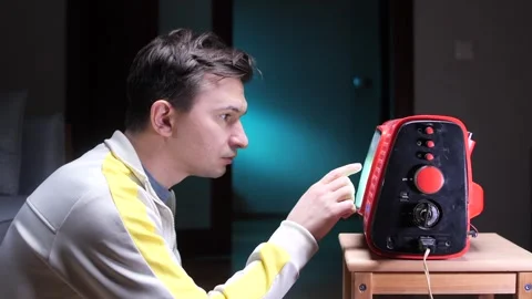 Man staring at old tube TV screen with static and reaching out to screen Stock Footage 302222553