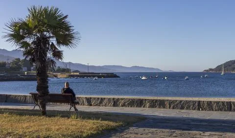 Man staring at the sea on the Shell's Beach in Cee, Galicia, Spain. Stock Photos