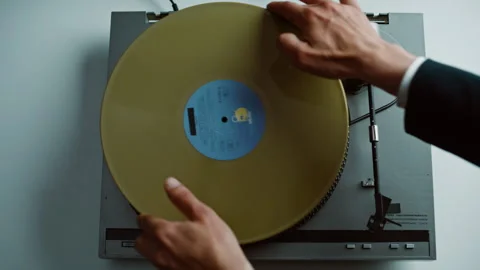 Man start vinyl play putting yellow disc on classic gramophone at home closeup. Stock Footage 332620739