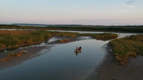 Man starting a boat in a river at sunset Stock Footage 254980133