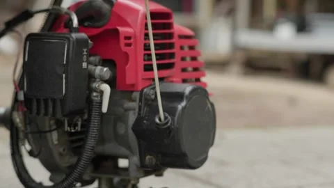 Man Starting a Brush Cutter Engine in a Rural Orchard Stock Footage 344848801